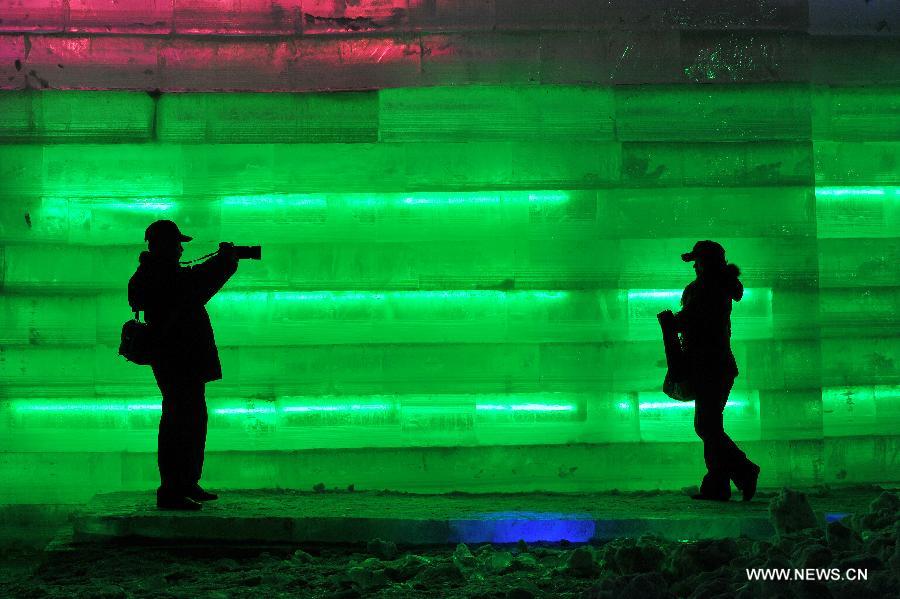 Local residents take photos in front of an ice sculpture on display at an ice and lantern art festival in Hengcheng scenic spot of Yinchuan, capital of northwest China's Ningxia Hui Autonomous Region, Jan. 25, 2013. The festival kicked off here on Friday. (Xinhua/Peng Zhaozhi) 