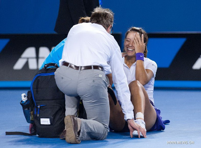 Li Na (R) of China receives treatment from medical staff after falling during the women's singles final match against Victoria Azarenka of Belarus at the 2013 Australian Open tennis tournament in Melbourne, Australia, Jan. 26, 2013. Azarenka won 2-1 to claim the title. (Xinhua/Bai Xue) 