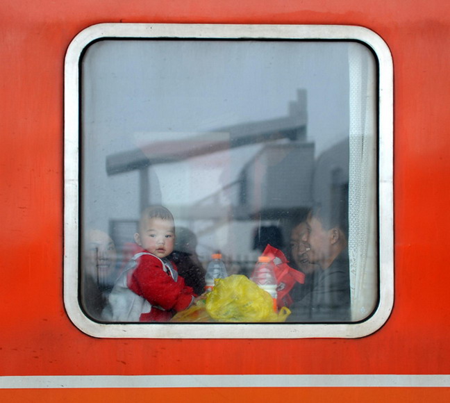 A baby looks out the window of a train at Zhangjiajie Railway Station in Hunan province, Jan 26, 2013. (Photo/Xinhua) 