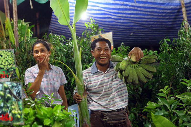 Chatree Plikkamsook (right), 43, sells bananas at a night market in Chiang Mai.