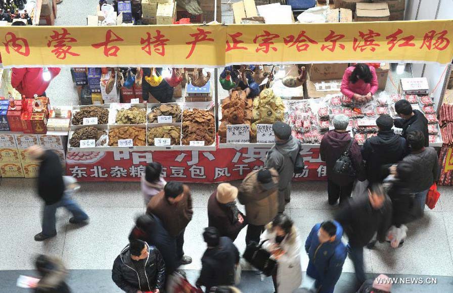 Customers are seen selecting goods on a market in Jinan, capital of east China's Shandong Province, Jan. 26, 2013. A 10-day fair, which kicked off here on Saturday, offers local customers goods and supplies from more than 800 retailers prior to the Chinese Spring Festival which falls on Feb. 10 this year. (Xinhua/Xu Suhui) 