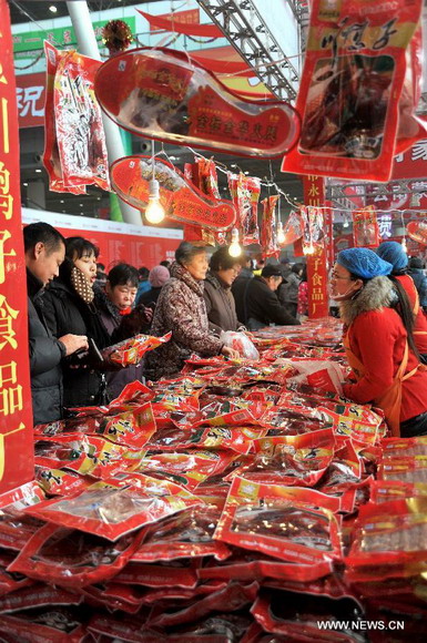 Customers are seen selecting goods on a market in Jinan, capital of east China's Shandong Province, Jan. 26, 2013. A 10-day fair, which kicked off here on Saturday, offers local customers goods and supplies from more than 800 retailers prior to the Chinese Spring Festival which falls on Feb. 10 this year. (Xinhua/Xu Suhui) 