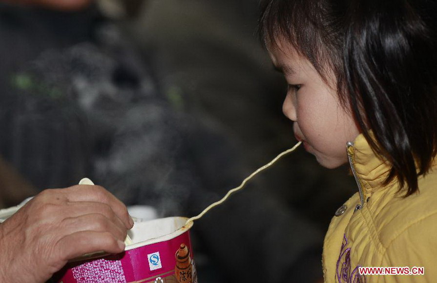 A child eats instant noodles at the waiting hall of railway station in Liuzhou City, south China's Guangxi Zhuang Autonomous Region, Jan. 26, 2013. The 40-day Spring Festival travel rush started Saturday. (Xinhua/Zhang Cunli) 