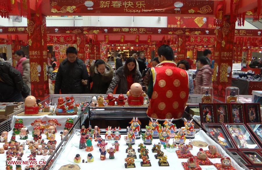Customers select craftworks for the upcoming Spring Festival at a shopping mall in Beijing, capital of China, Jan. 27, 2013. Retailers all around the country take many kinds of sales boosting measures to attract shoppers as Chinese Spring Festival approaches. (Xinhua/Li Xin)