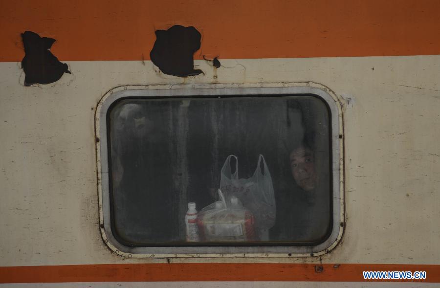A man looks out of a window on a train from Hangzhou to Zhengzhou, capital of central China's Henan Province, at Hangzhou train station in Hangzhou, capital of east China's Zhejiang Province, Jan. 27, 2013. The 40-day Spring Festival travel rush began on Saturday. The Spring Festival, the most important occasion for a family reunion for the Chinese people, falls on the first day of the first month of the traditional Chinese lunar calendar, or Feb. 10 this year. (Xinhua/Han Chuanhao)
