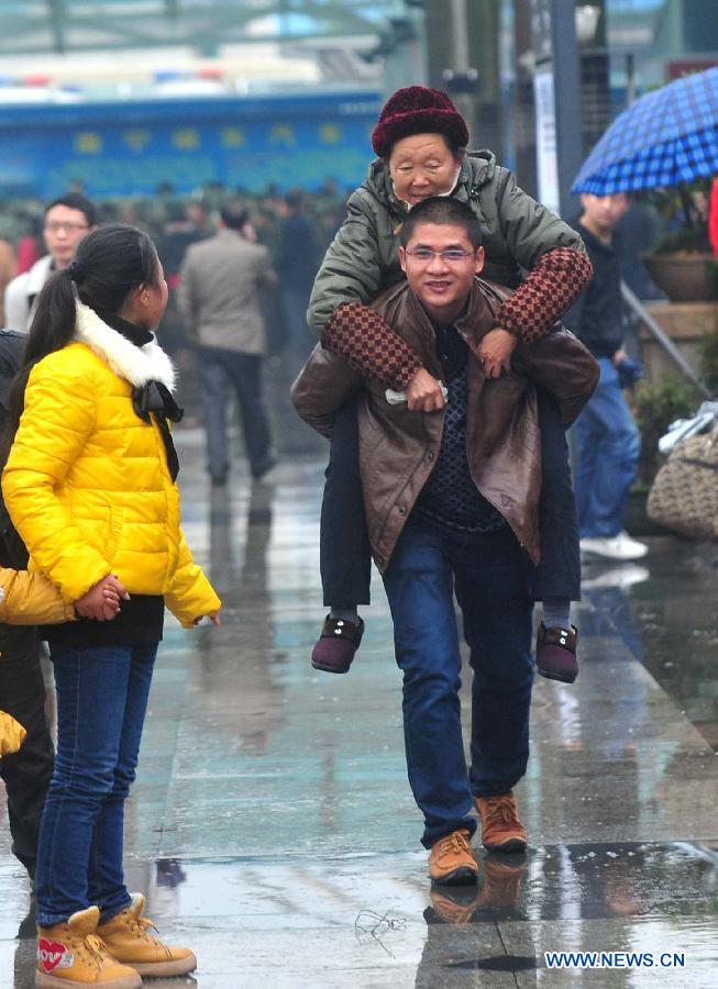 A man carries his mother-in-law heading to the Nanning Railway Station in Nanning, capital of south China's Guangxi Zhuang Autonomous Region, Jan. 26, 2013. As the Spring Festival, which falls on Feb. 10 this year, draws near, lots of people rushed to start their journey home. (Xinhua/Huang Xiaobang)