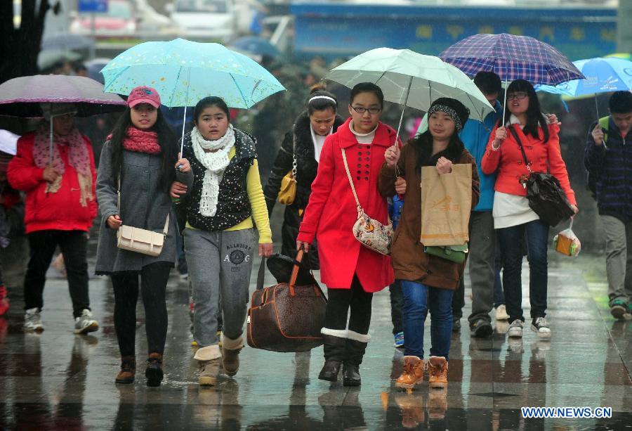 Passengers make their way to the railway station in the rain on the square of the Nanning Railway Station in Nanning, capital of south China's Guangxi Zhuang Autonomous Region, Jan. 26, 2013. As the Spring Festival, which falls on Feb. 10 this year, draws near, lots of people rushed to start their journey home. (Xinhua/Huang Xiaobang)