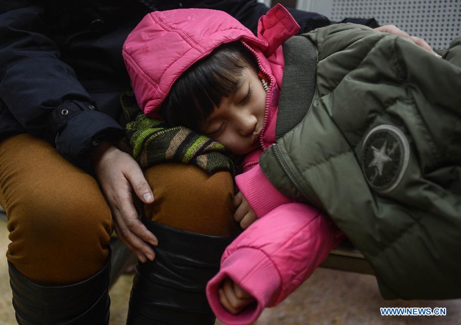 A girl heading for Qiqihaer in northeast China's Heilongjiang Province sleeps on the legs of her family member at Hangzhou train station in Hangzhou, capital of east China's Zhejiang Province, Jan. 27, 2013. The 40-day Spring Festival travel rush began on Saturday. The Spring Festival, the most important occasion for a family reunion for the Chinese people, falls on the first day of the first month of the traditional Chinese lunar calendar, or Feb. 10 this year. (Xinhua/Han Chuanhao)