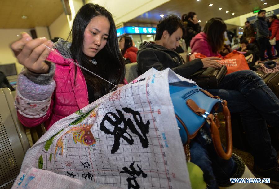 Gong Pinghui, a 25-year-old girl from northwest China's Shaanxi Province, makes cross-stitch embroidery while waiting for her train home at Hangzhou train station in Hangzhou, capital of east China's Zhejiang Province, Jan. 27, 2013. Gong now does foreign trade in Zhejiang's Yiwu. The 40-day Spring Festival travel rush began on Saturday. The Spring Festival, the most important occasion for a family reunion for the Chinese people, falls on the first day of the first month of the traditional Chinese lunar calendar, or Feb. 10 this year. (Xinhua/Han Chuanhao)
