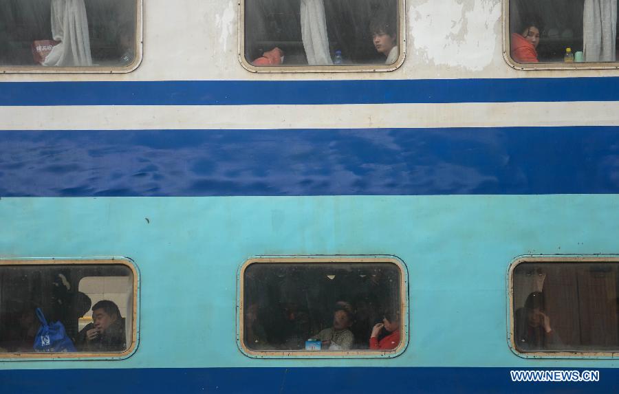 Passengers on a double-decker train look out of the windows while the train stops at Hangzhou train station in Hangzhou, capital of east China's Zhejiang Province, Jan. 27, 2013. The 40-day Spring Festival travel rush began on Saturday. The Spring Festival, the most important occasion for a family reunion for the Chinese people, falls on the first day of the first month of the traditional Chinese lunar calendar, or Feb. 10 this year. (Xinhua/Han Chuanhao)