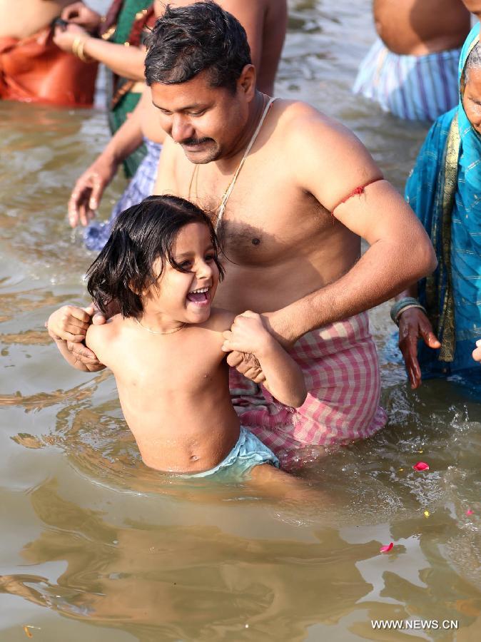 A Hindu devotee and his daughter take bath in Triveni Sangam during Maha Kumbh Mela festival in Allahabad, a city in west uttar Predash, India, Jan. 27, 2013. (Xinhua/Li Yigang)