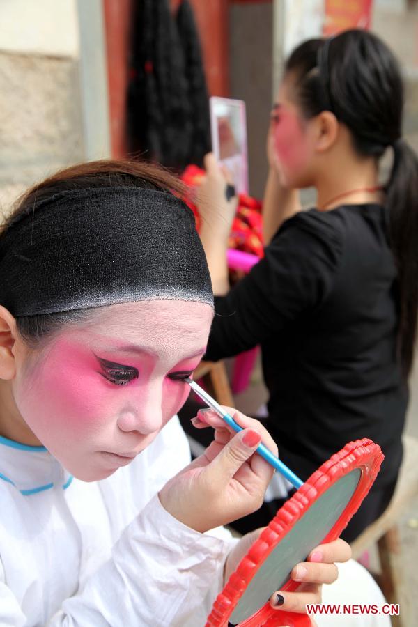 Learners of Puxian opera, one of the oldest forms of Chinese opera, make up for performance at the Dongqin Village in Putian City, southeast China's Fujian Province, Jan. 26, 2013. Puxian opera, which originated from puppet shows, has been listed as a national intangible cultural heritage. (Xinhua/Lin Jianbing)