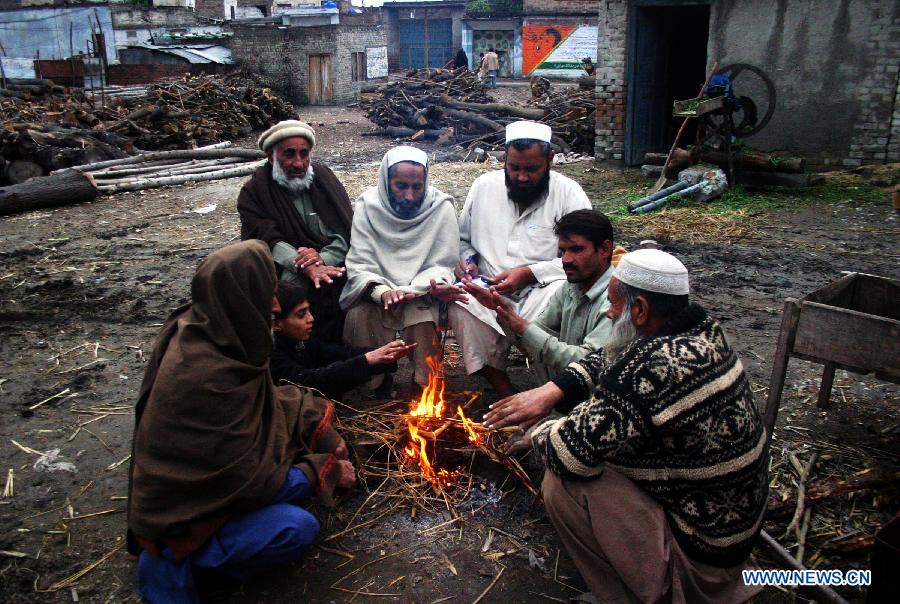 Local residents warm themselves as they sit around fire during cold morning in northwest Pakistan's Peshawar on Jan. 27, 2013. (Xinhua/Ahmad Sidique)