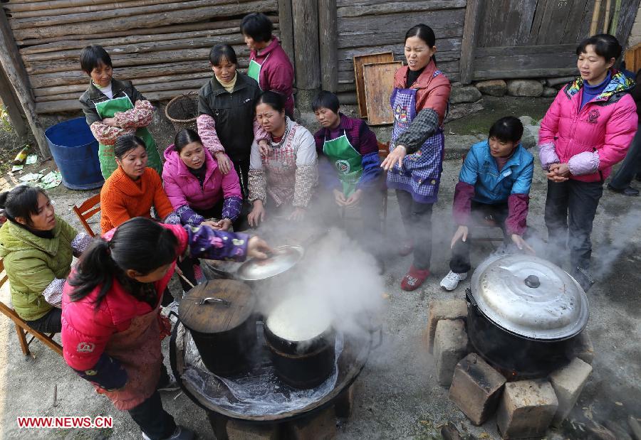 Woman of Zhuang ethnic group cook glutinous rice for a wedding dinner at Chanru Village of Wangdong Town in Rongshui County, south China's Guangxi Zhuang Autonomous Region, Jan. 27, 2013. (Xinhua/Long Tao) 