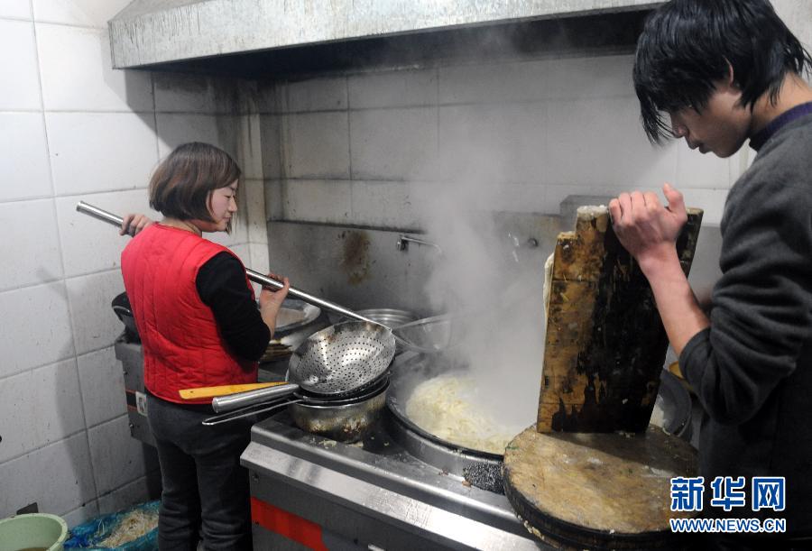 The restaurant owner's wife, Jin Xiaomin (left), makes noodles on Jan. 25, 2013.