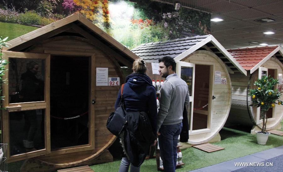 A couple looks at sauna cabins at the International Green Week agriculture and food fair in Berlin, Germany, Jan. 27, 2013. The 2013 International Green Week agriculture and food fair was closed on Sunday. (Xinhua/Pan Xu)