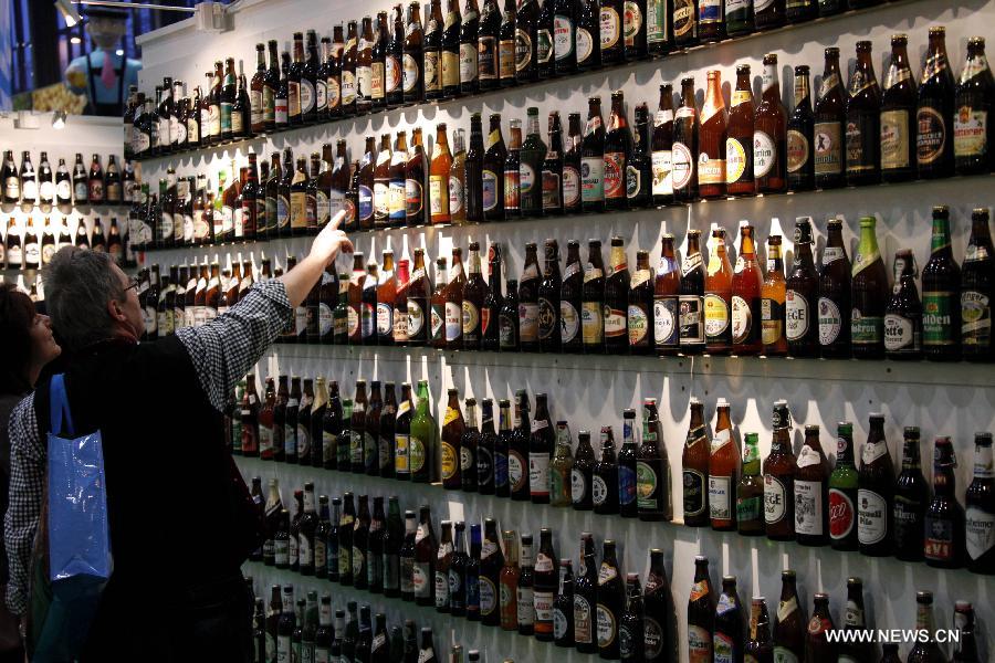 A man looks at the displayed beer bottles at the International Green Week agriculture and food fair in Berlin, Germany, Jan. 27, 2013. The 2013 International Green Week agriculture and food fair was closed on Sunday. (Xinhua/Pan Xu)