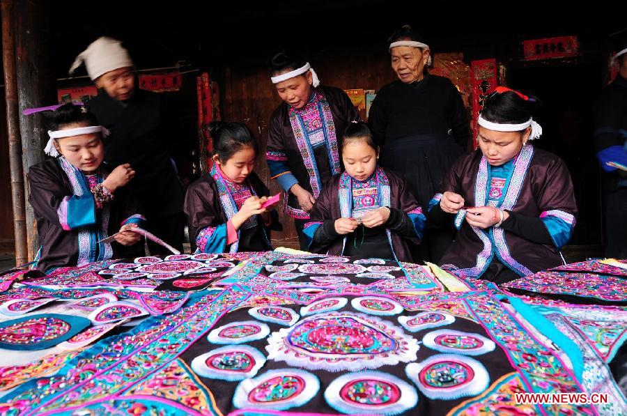 Women of Dong ethnic group make embroidery works at Tongle Village in Sanjiang Dong Autonomous County, southwest China's Guangxi Zhuang Autonomous Region, Jan. 26, 2013. The embroidery works made by Dong women have been sold to Britain. (Xinhua/Liang Kechuan) 
