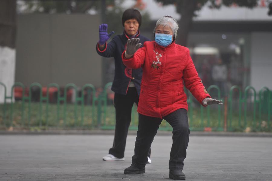 Citizens do morning exercises amid heavy fog in Hangzhou, capital of east China's Zhejiang Province, Jan. 28, 2013. The provincial meteorological observatory has issued an orange-coded alert on Jan. 28 morning as foggy weather here cut visibility to less than 500 meters and worsened air pollution in many cities. (Xinhua/Huang Zongzhi) 