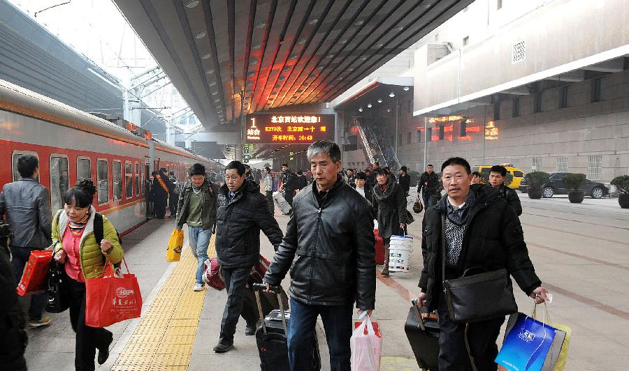 Passengers walk on the platform to get on a train at Beijing West Railway Station in Beijing, capital of China, Jan. 27, 2013. China's Lunar New Year travel rush kicked off on Jan. 26 this year and a record 3.41 billion trips are expected to be made over this year's Lunar New Year travel rush, as Chinese who have worked away from home see the holiday as the most important occasion for family reunion. (Xinhua/He Junchang) 