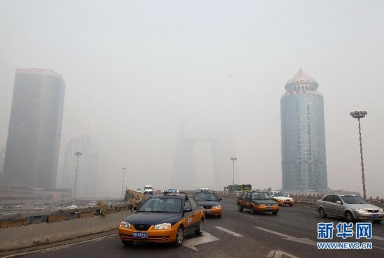 Vehicles travel in fog shrouded East Third Ring Road of Beijing, Jan. 27, 2013. Beijing's meteorological center on Monday issued a yellow-coded alert for haze as the fourth foggy weather in this month hit the city and cuts the visibility below 3,000 meters in major parts of Beijing. (Photo/Xinhua) 