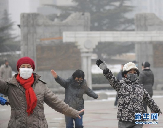 Several mask-wearing people have exercise in Shijingshan district, Beijing, Jan. 23. Beijing's meteorological center on Monday issued a yellow-coded alert for haze as the fourth foggy weather in this month hit the city and cuts the visibility below 3,000 meters in major parts of Beijing. (Photo/Xinhua)