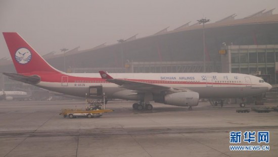 A photo taken on Jan. 13 shows a plane at the fog shrouded Beijing Capital International Airport. Beijing's meteorological center on Monday issued a yellow-coded alert for haze as the fourth foggy weather in this month hit the city and cuts the visibility below 3,000 meters in major parts of Beijing. (Photo/Xinhua)