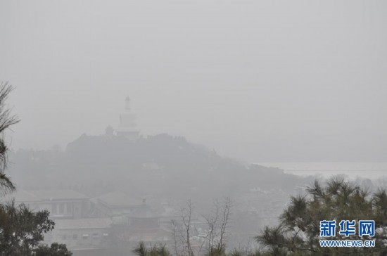 A photo taken on Jan. 23 shows the Beihai Park looming in the heavy fog. Beijing's meteorological center on Monday issued a yellow-coded alert for haze as the fourth foggy weather in this month hit the city and cuts the visibility below 3,000 meters in major parts of Beijing. (Photo/Xinhua)