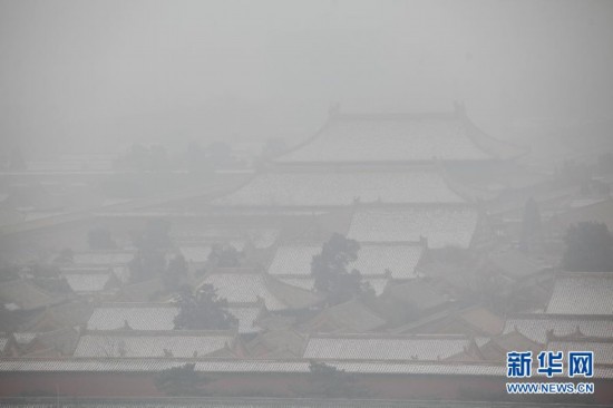 A photo taken on Jan. 23 shows the Forbidden City looming in the heavy fog. Beijing's meteorological center on Monday issued a yellow-coded alert for haze as the fourth foggy weather in this month hit the city and cuts the visibility below 3,000 meters in major parts of Beijing. (Photo/Xinhua)