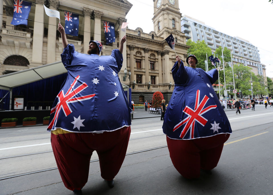 Two participants wave Australian national flags as they take part in a parade to mark the National Day in Melbourne, Australia, Jan. 26, 2013. (Xinhua)