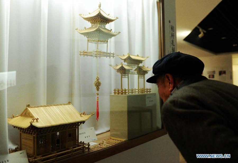 A visitor looks at artworks presented during an exhibition of traditional culture in Shijiazhuang, capital of north China's Hebei Province, Jan. 28, 2013. An 8-day exhibition in celebration of the coming Spring Festival was held in Shijiazhuang on Monday. (Xinhua/Zhu Xudong)