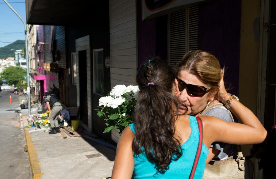 A woman comes to lay flowers at the accident site of "Kiss" nightclub in Santa Maria, Brazil, on Jan. 28, 2013. (Xinhua/Weng Xinyang) 