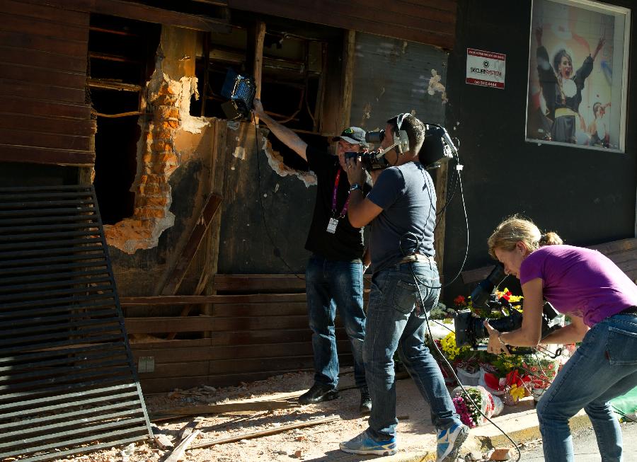 Journalists report at the fire site of "Kiss" nightclub in Santa Maria, Brazil, on Jan. 28, 2013. (Xinhua/Weng Xinyang)