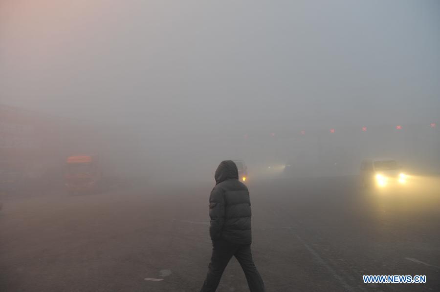A citizen walks amid fog in Hefei, east China's Anhui Province, Jan. 28, 2013. The National Meteorological Center (NMC) issued a blue-coded alert on Jan. 27 as foggy weather forecast for the coming two days will cut visibility and worsen air pollution in some central and eastern Chinese cities. (Xinhua/Yang Xiaoyuan)