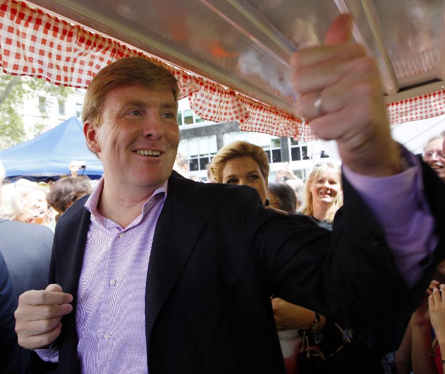Dutch Crown Prince Willem-Alexander is seen giving the thumbs-up to a pastry shop as he and Crown Princess Maxima (rear) walk through "New Amsterdam Village," in New York on this September 13, 2009 file photo.(Xinhua/Reuters)
