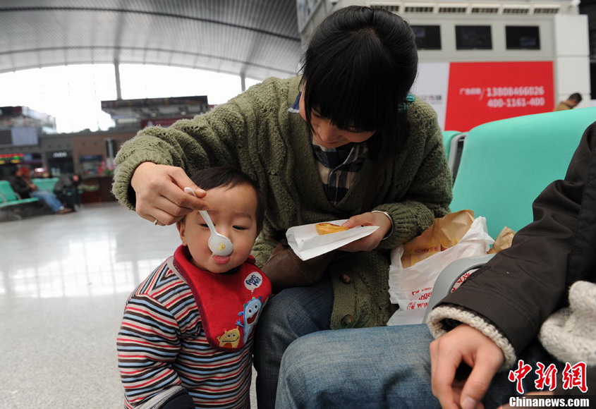 Love: A mother feeds tart to his kid in the waiting hall at Changshang Railway station on Jan 26, 2013. (CNS/Yang Hufeng)