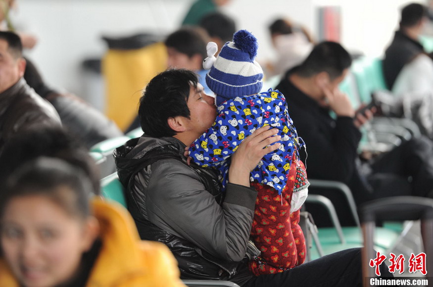 Father's kiss: A father kisses his kid in the waiting hall of Shangsha South Railway Station on Jan. 26, 2013. (CNS/Yang Huafeng)