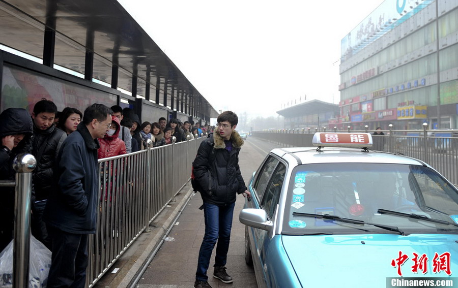 Difficult to get a cab: Travelers wait in queue to take a cab heading to home in cold winter at Jinan Railway Station on Jan. 26, 2013. (CNS/ Zhang Yong)
