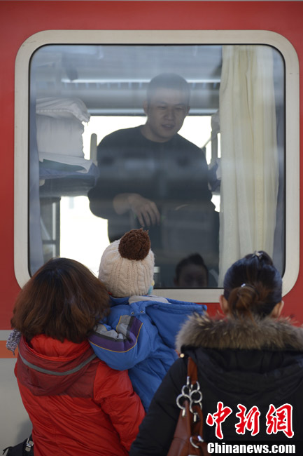 Farewell at railway station: A man says goodbye to his family at Hohhot Railway Station of Inner Mongolia on Jan. 26, 2013. (CNS/ Liu Wenhua)