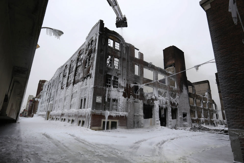 Firefighters spray down hot spots on an ice-covered warehouse that caught fire at night in Chicago, U.S., Jan. 23, 2013. (Xinhua/AP)