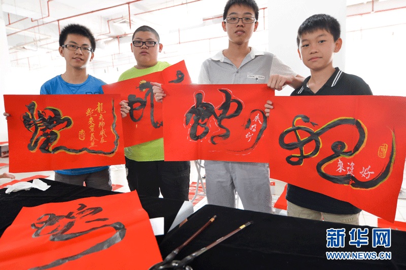 Contestants present their calligraphy works "she", meaning snake in Chinese, on Sunday in Selangor, Malaysia. (Xinhua Photo by Zhang Wenzong)