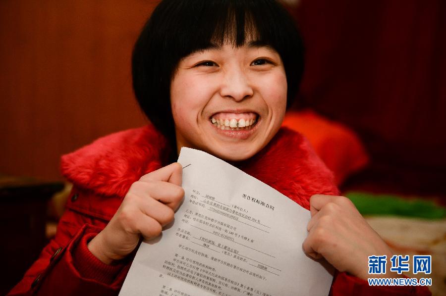 Liu Xiaolin presents her signed copyright contract with Heilongjiang digital publishing Co., Ltd. on Jan. 25 (Xinhua/ Guo Xulei)