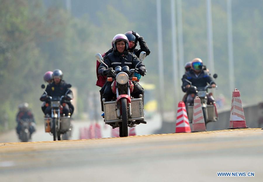 Migrant workers ride motorbikes on their way back home on the 321 National Highway in Wuzhou, south China's Guangxi Zhuang Autonomous Region, Jan. 29, 2013. Many Guangxi migrant workers working in south China's Guangdong Province got around the ticket buying predicament during the Spring Festival travel rush which lasts for forty days by riding back home thanks to the well-developed roads connecting Guangxi and Guangdong. (Xinhua/Huang Xiaobang)