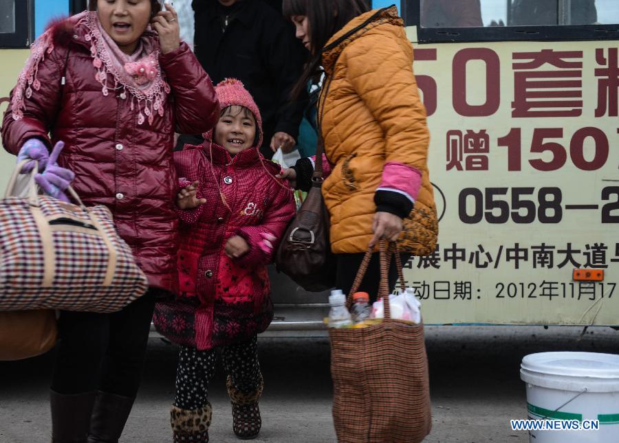 Liu Pingping (C) gets off the bus after arriving at her home town in Yingzhou District in Fuyang of east China's Anhui Province, in the morning of Jan. 29, 2013. (Xinhua/Han Chuanhao)
