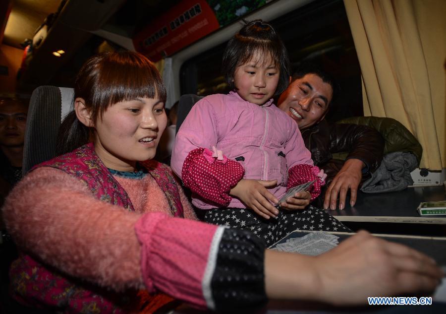 Chen Yan (L) plays cards with her daughter Liu Pingping (C) on a train heading to Fuyang of east China's Anhui Province, Jan. 28 , 2013. (Xinhua/Huang Zongzhi) 