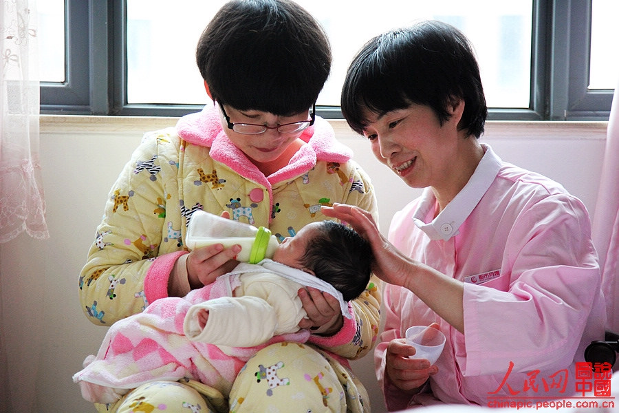 Zhang guides the mother to breast-feed the baby in a right way.