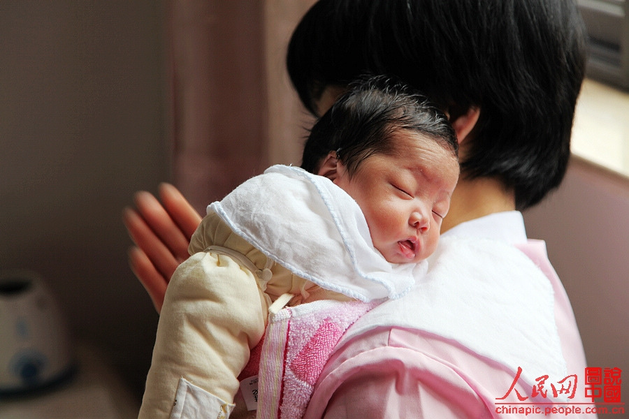 After feeding the baby, Zhang lets the baby lean on her should and pats the baby's back softly to help the digestion.