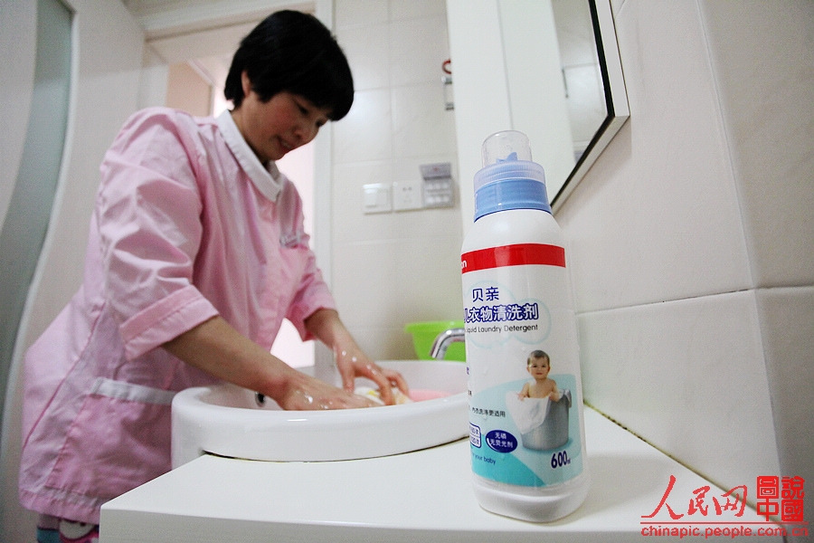 Zhang washes the baby's clothes by hand.