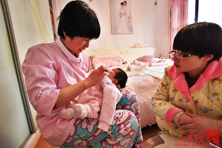 Zhang wipes the baby's face.