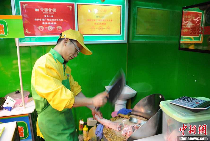 Hao Chengbin (R), a graduate from Jiangxi University of Finance and Economics, cuts pork for customer on Jan. 29, 2013. (Photo/CNS)